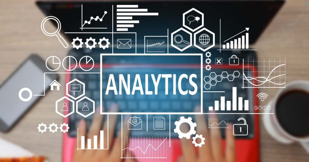 Hands typing on a laptop with the word "Analytics" surrounded by data charts, graphs, and digital icons.